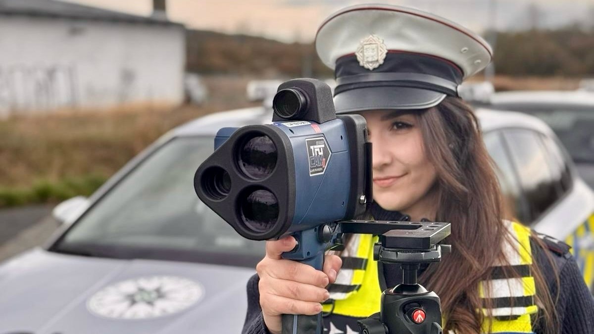 Czech policewoman is measuring speed with a radar gun